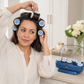 Blue hair roller set with 12 jumbo rollers held near a person’s hair