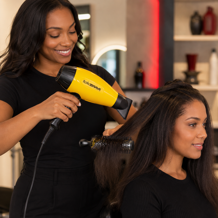 Yellow and black hair dryer being used to blow-dry long dark hair