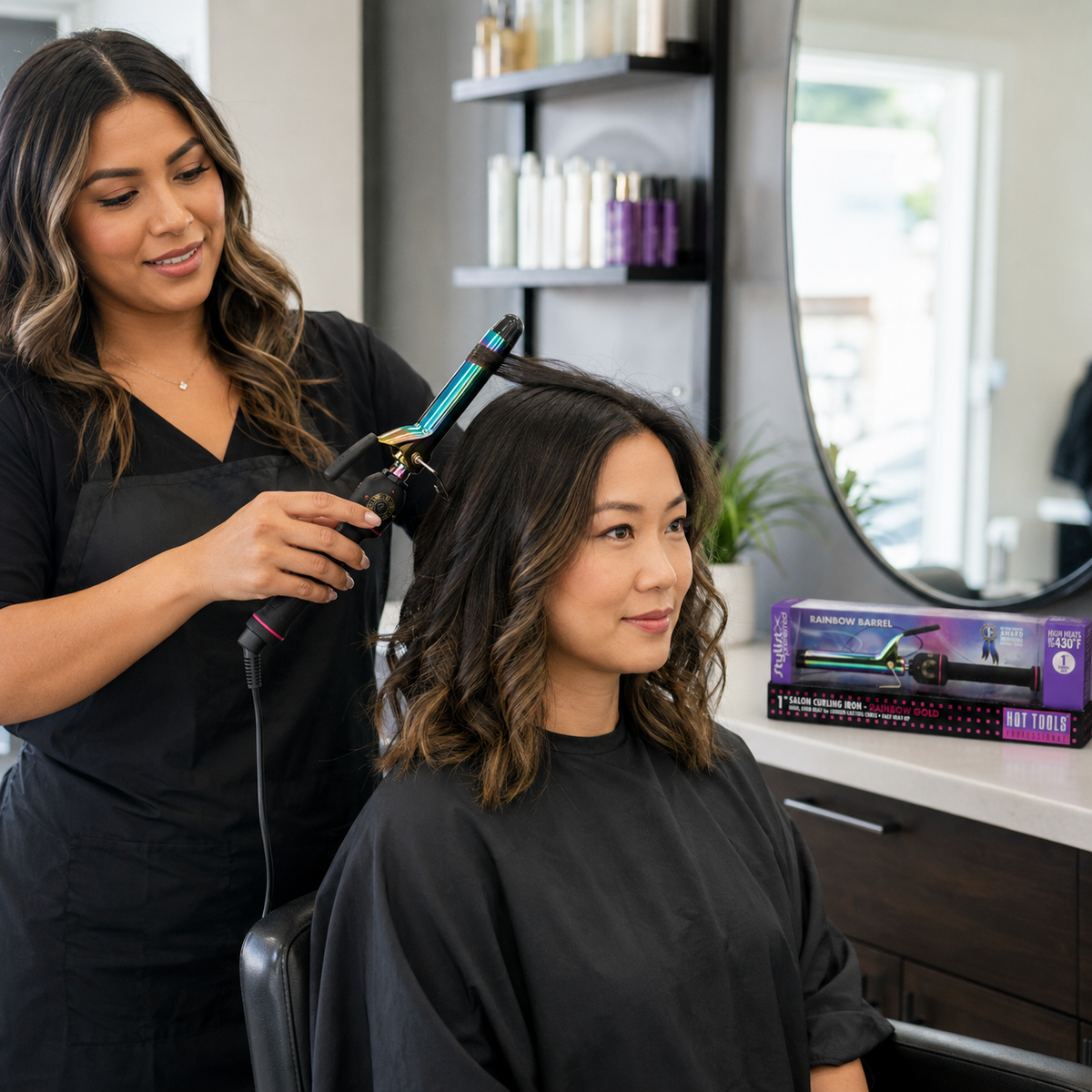 Stylist holding an iridescent rainbow barrel curling iron with black handle